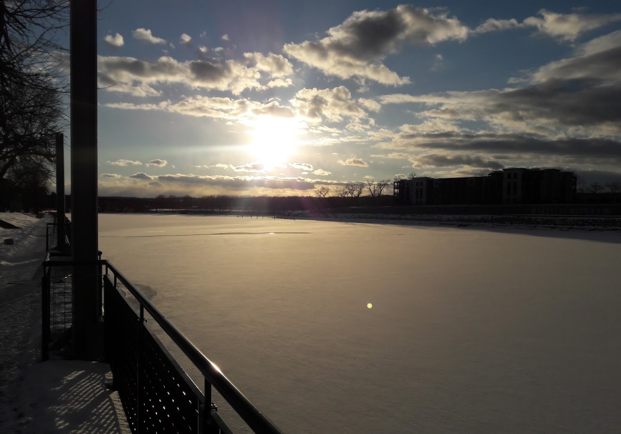 sunset behind a river walk railing